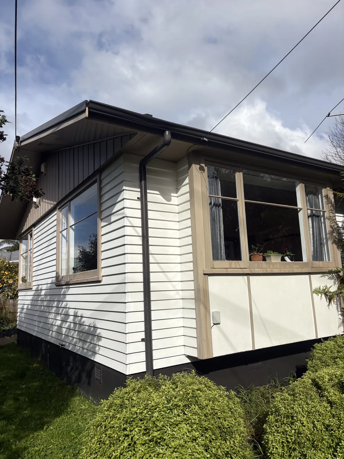 White weatherboard bungalow with clean cladding and joinery after a house wash